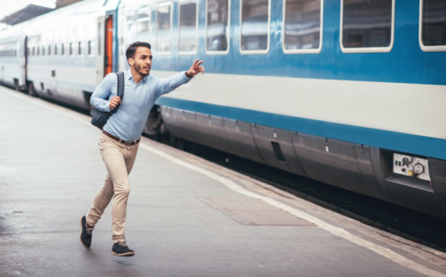 Ein junger Auszubildener läuft am Bahnsteig seinem Zug hinterher